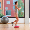 A woman standing on a soft cushion with one leg, slightly lifting the other leg