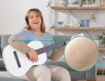 Frau mit Juzo Expert mit Funktionszone Ellenbogen sitzt auf dem Sofa und spielt Gitarre