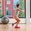 A woman standing on a soft cushion with one leg, doing a squat